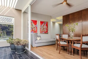 Ein modernes Interieur mit einem Essbereich, einer Couch und abstrakten Gemälden.