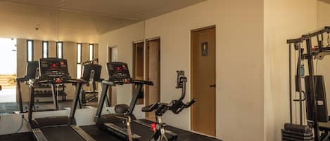 A gym with treadmills, a stationary bike, and weightlifting equipment.
