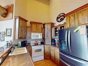 Une cuisine avec des meubles en bois, un réfrigérateur en acier inoxydable, un four à micro-ondes et une cuisinière.
