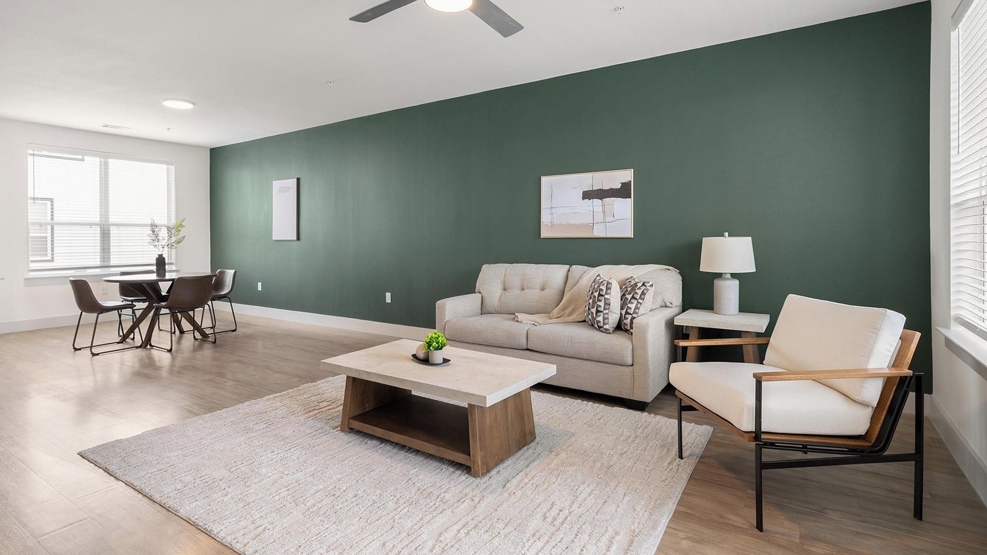A living room with a green wall, a sofa, a coffee table, and a chair.