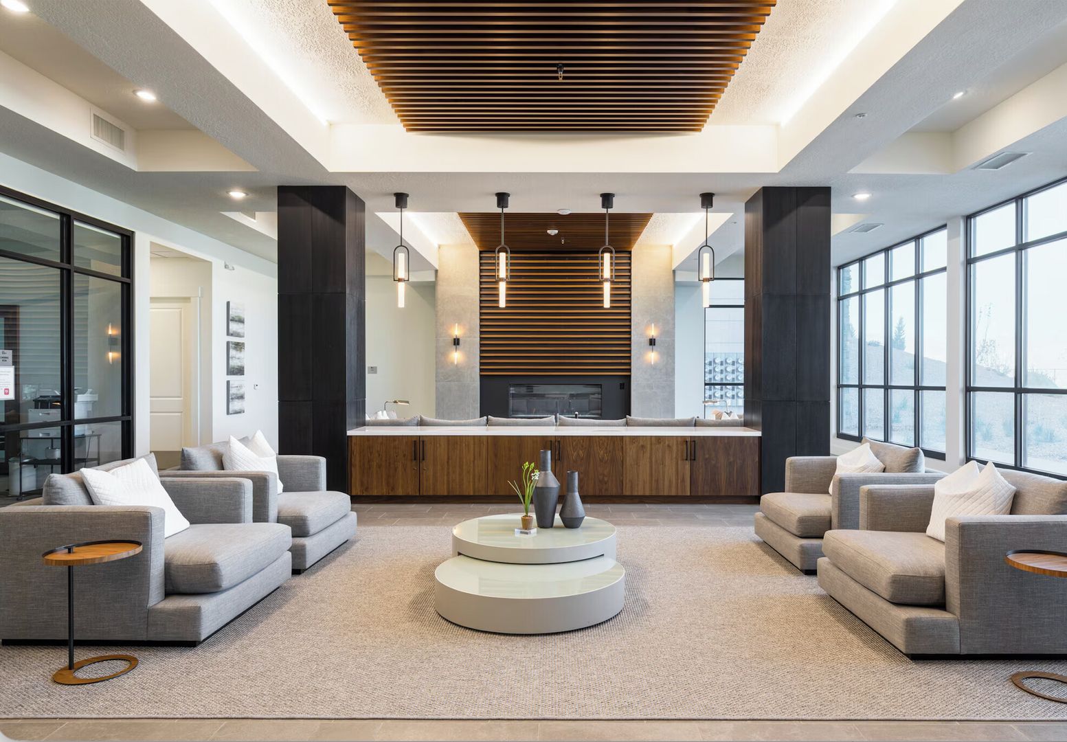 A modern living room with a central coffee table, sofas, and a fireplace.