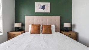 A neatly made bed with two pillows, a headboard, and two bedside tables with lamps. - Landing | Modern 1BD, Yoga Studio, Gym (Sarasota)