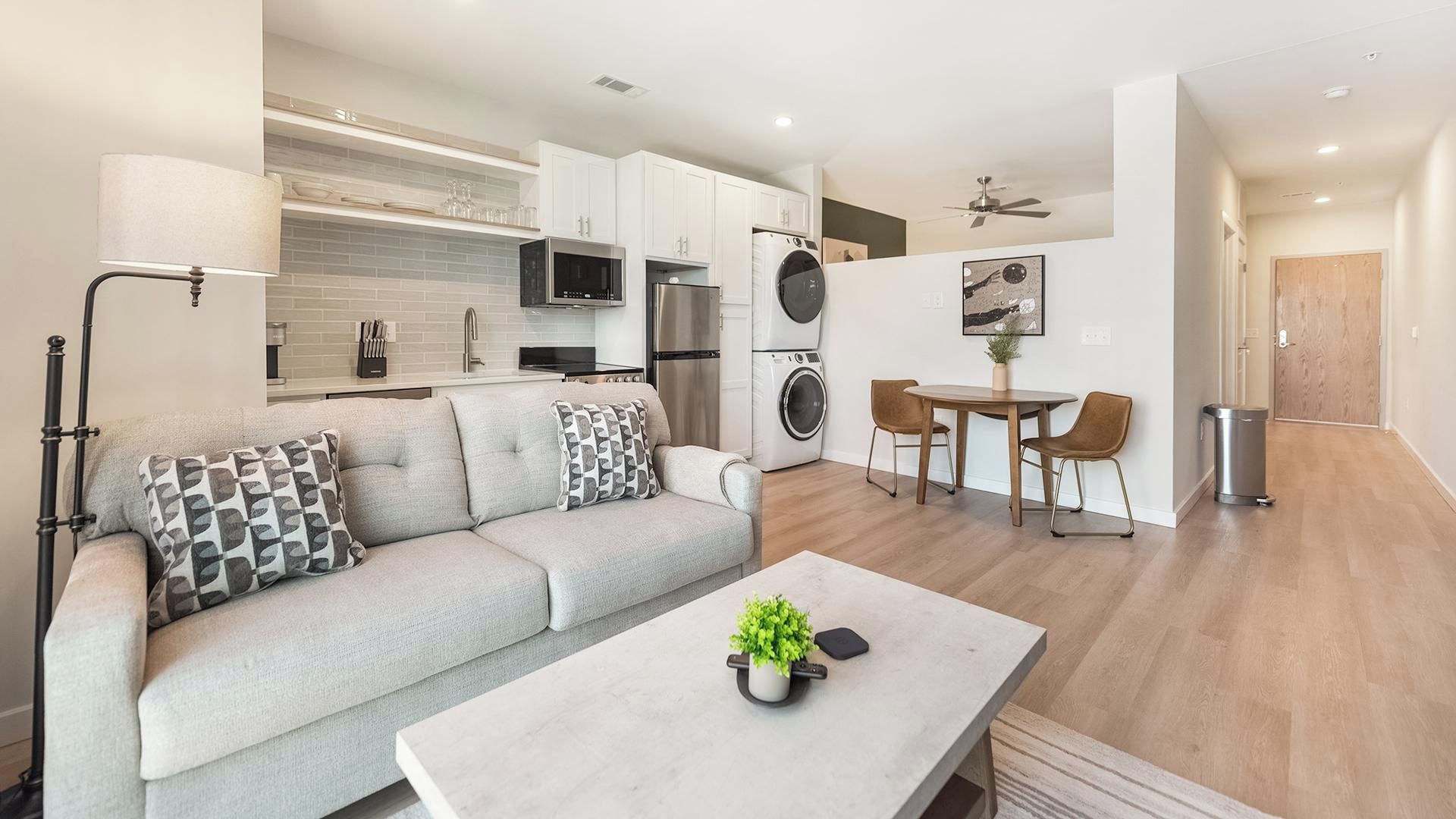 Een modern appartement met een woongedeelte, kitchenette en eetruimte.
