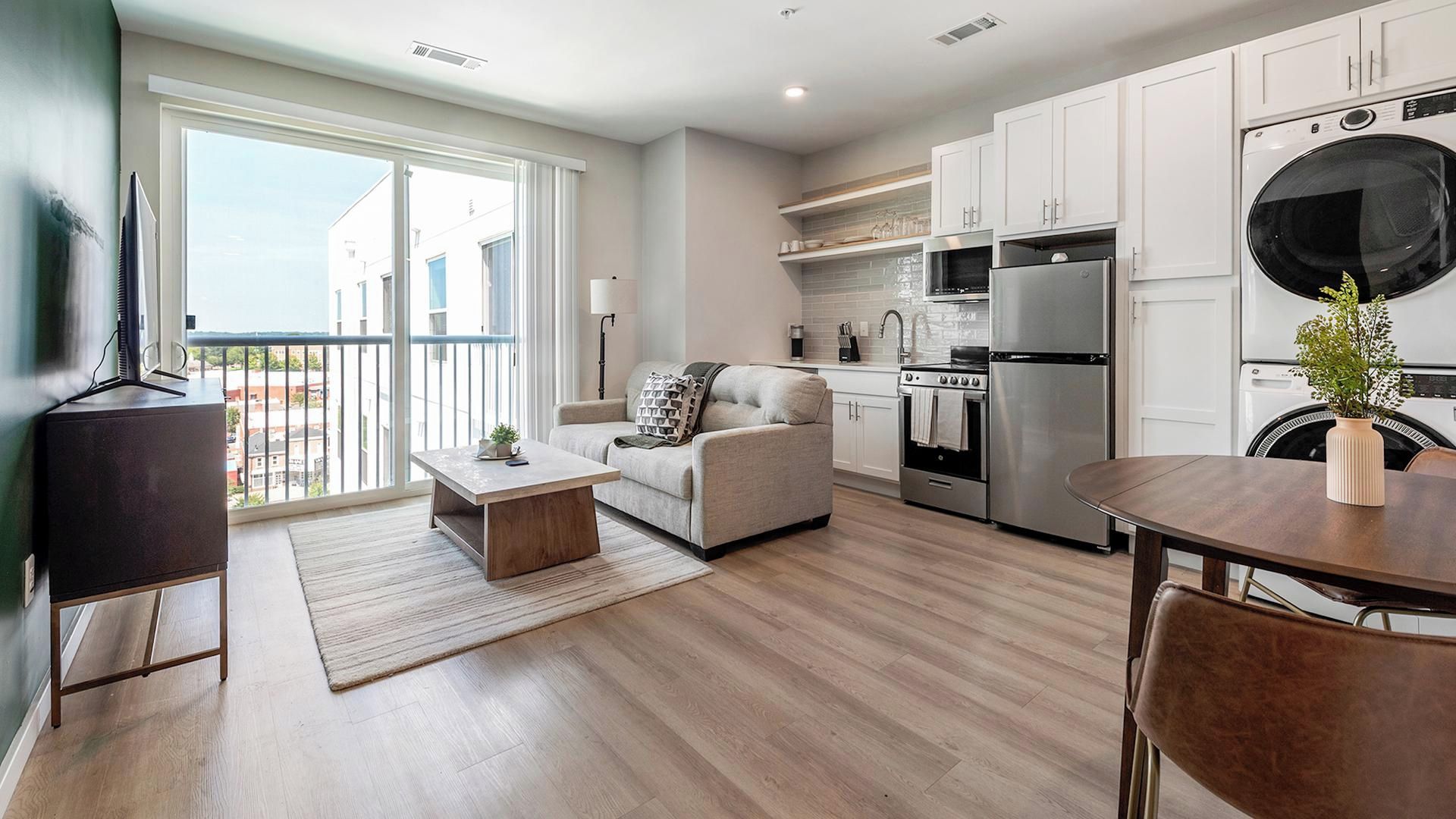 A modern apartment with a living area, kitchen, and dining space.