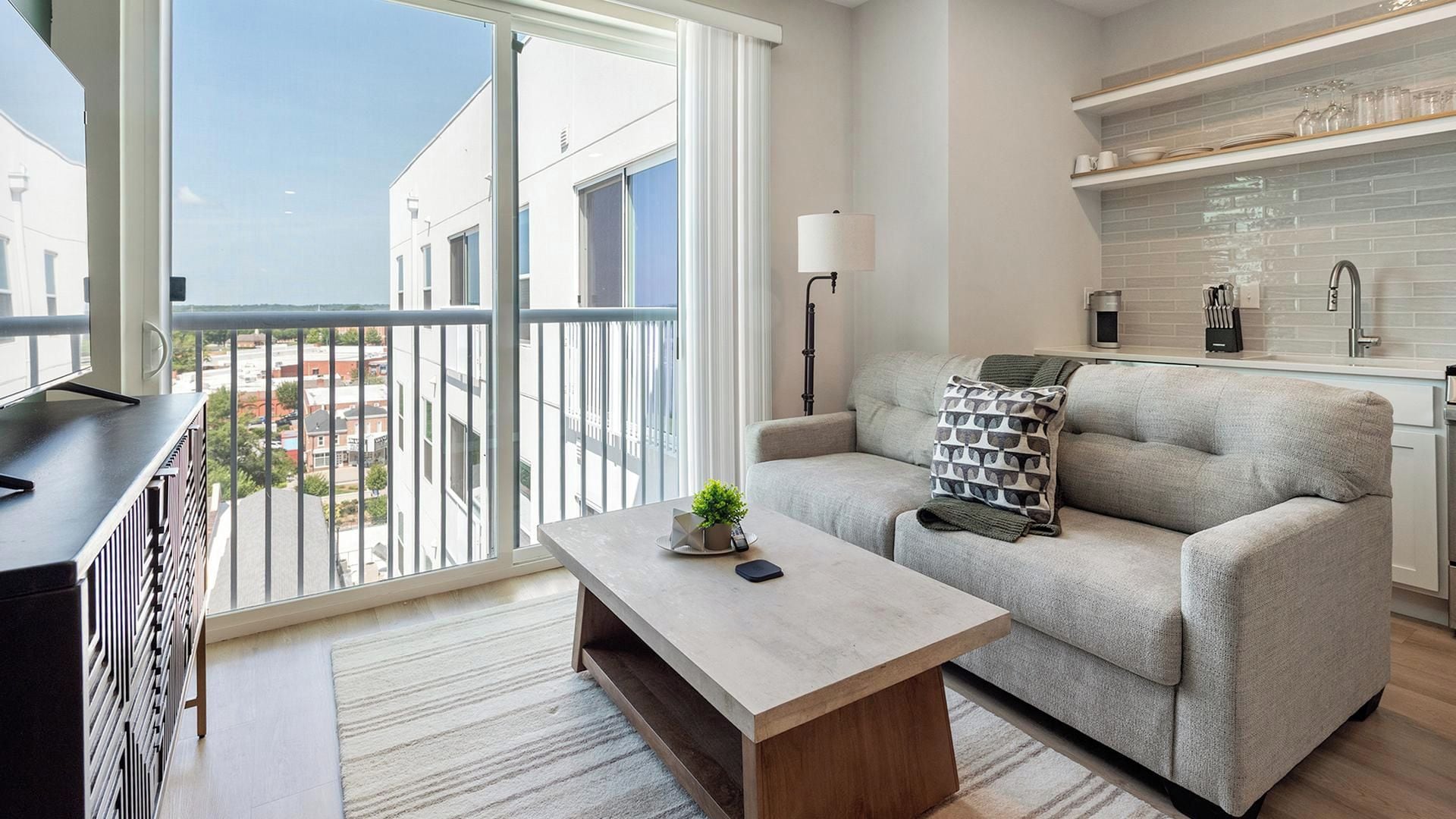 Un salon moderne avec un canapé, une table basse et une vue sur l’extérieur.