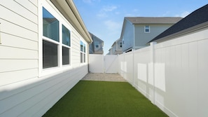 A residential area with white houses, a white fence, and a small grassy yard. - Landing | Stunning 2BD, Gym (Palmetto)