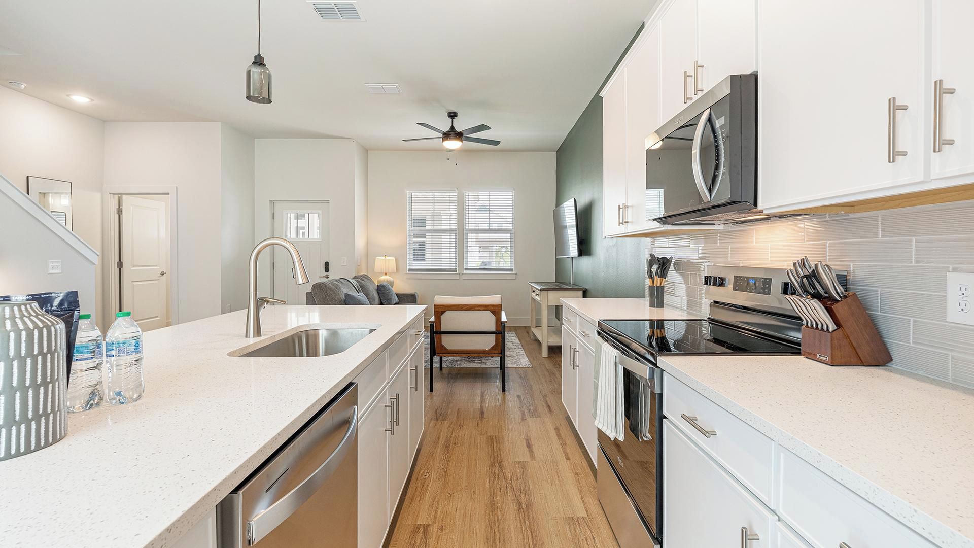 A modern kitchen with a central island, stainless steel appliances, and a microwave above the stove.