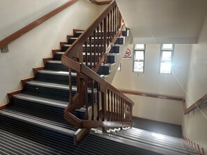 A wooden staircase with a handrail leading to an upper floor. - LN FLATS & SUÌTES (Uberlândia)