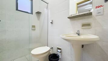 Un bagno con il water, un lavandino e un cestino.