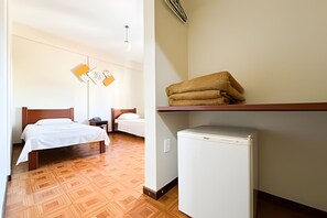 A hotel room with two beds, a small refrigerator, and a wall-mounted shelf with towels. - LN FLATS & SUÌTES (Uberlândia)