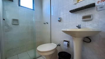 Un baño con inodoro, lavabo y una pequeña ventana.
