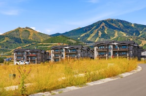 A hotel complex with multiple buildings, a road in front, and mountains in the background. - Family Friendly 3 Bedroom Condo Near Deer Valley East Village (Heber City)