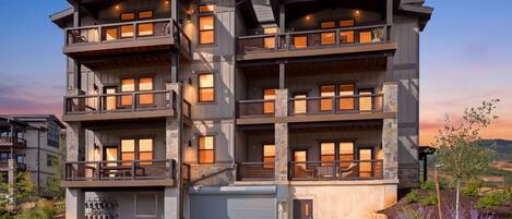 Un edificio residenziale a più piani con balconi, ampie finestre e un basculante per garage.