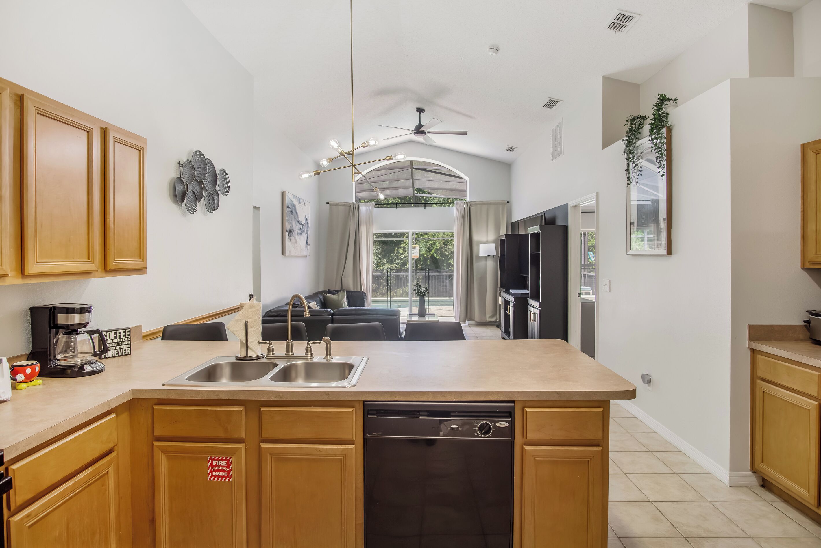 A modern kitchen with a central island, double sink, and a dishwasher.