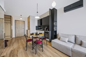 Eine moderne Wohnung mit Essbereich, Küchenzeile und einer Couch.