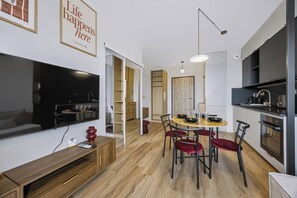 Ett modernt kök med matplats, TV och en bänk.