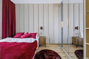 A modern bedroom with a bed, nightstands, a mirror, and a sliding door. - Warsaw Bemowo Apt — Parking, A/C & Balcony (Warszawa)