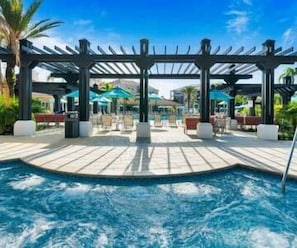 Ett poolområde med en pergola, solstolar och parasoller.