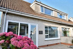 A two-story house with a tiled roof, a front door with glass panels, and a sign that reads 'GLEN.' - Seven Glen Portrush: stylish coastal escape near the beach (Portrush)