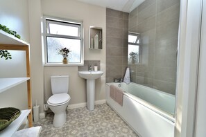 A bathroom with a toilet, sink, and bathtub. - Seven Glen: stylish coastal escape near the beach (Portrush)