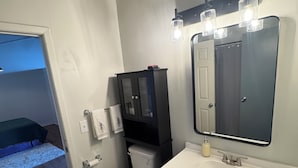 Ein kleines Badezimmer mit Toilette, Waschbecken und Spiegel.