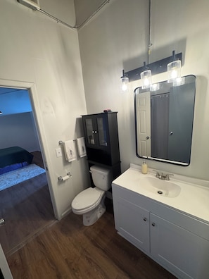 Ein kleines Badezimmer mit Toilette, Waschbecken und Spiegel.