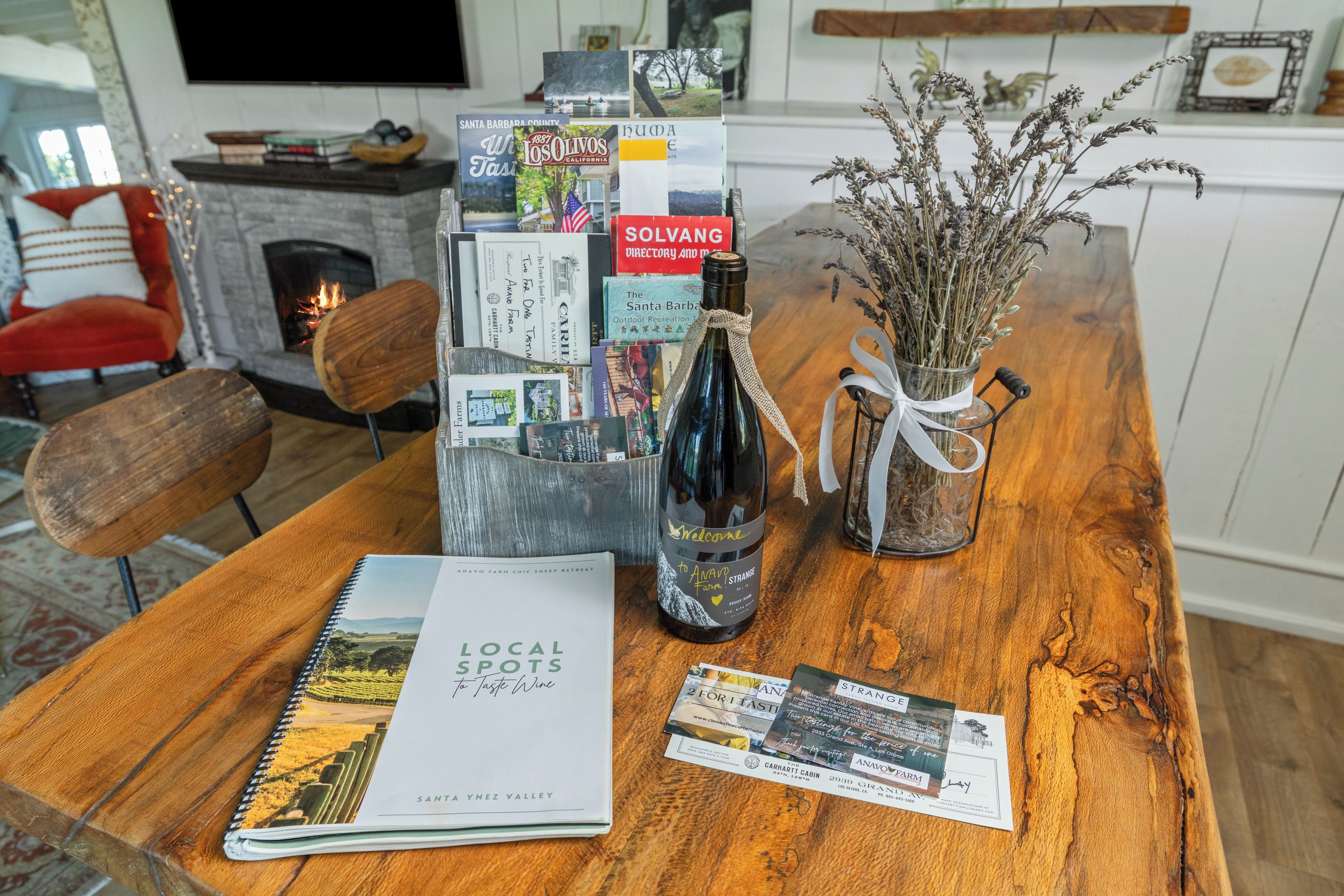 A wooden table with a wine bottle, a book titled 'Local Spots to Taste Wine,' and brochures.