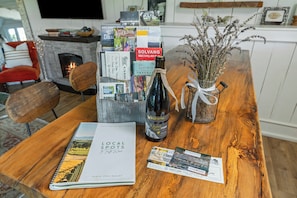 Una mesa de madera con una botella de vino, un libro titulado 'Local Spots to Taste Wine' y folletos.