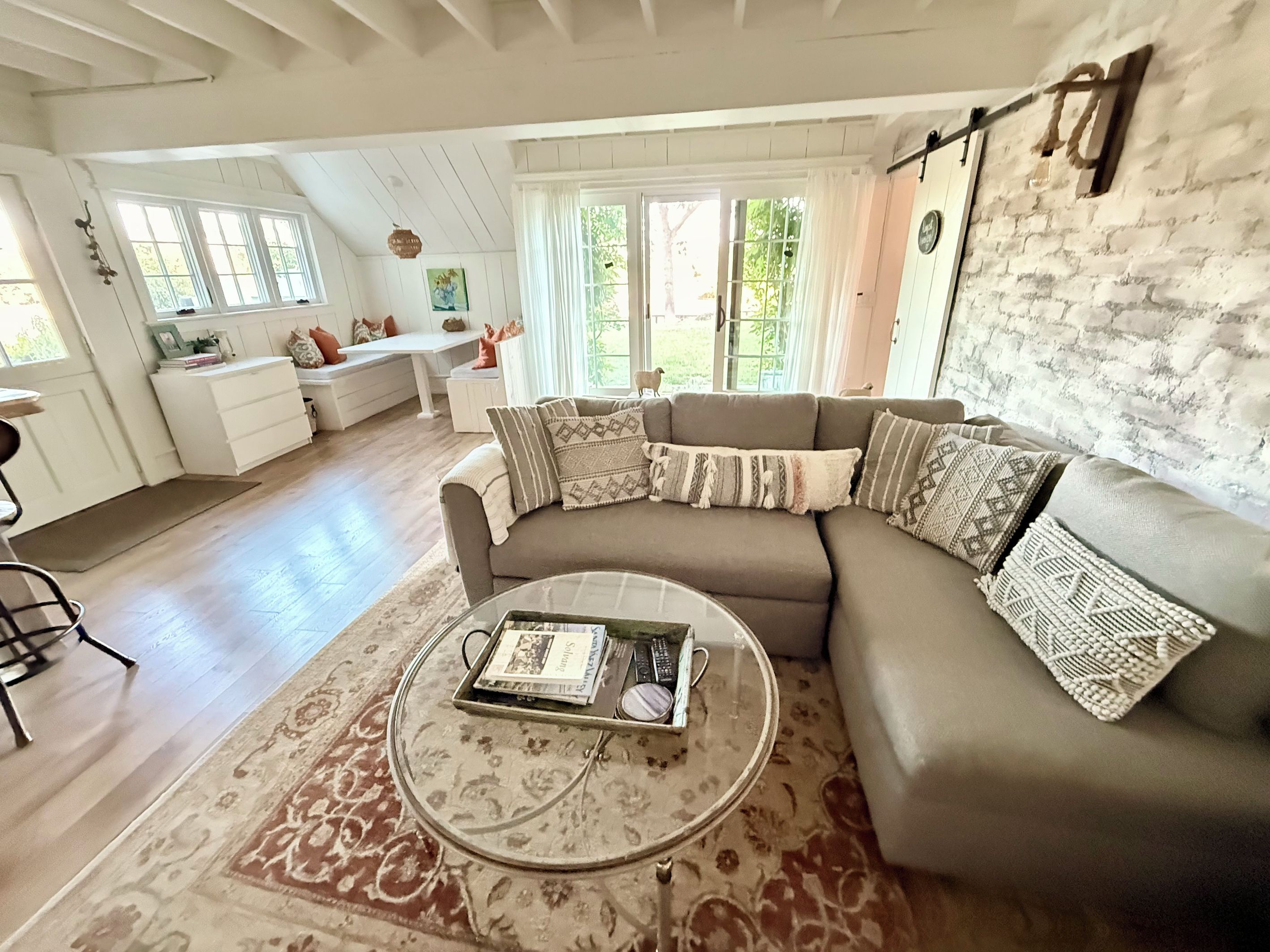 A living room with a sectional sofa, a coffee table, and a dining area with a bench.