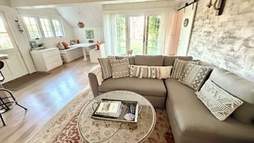 A living room with a sectional sofa, a coffee table, and a dining area with a bench.