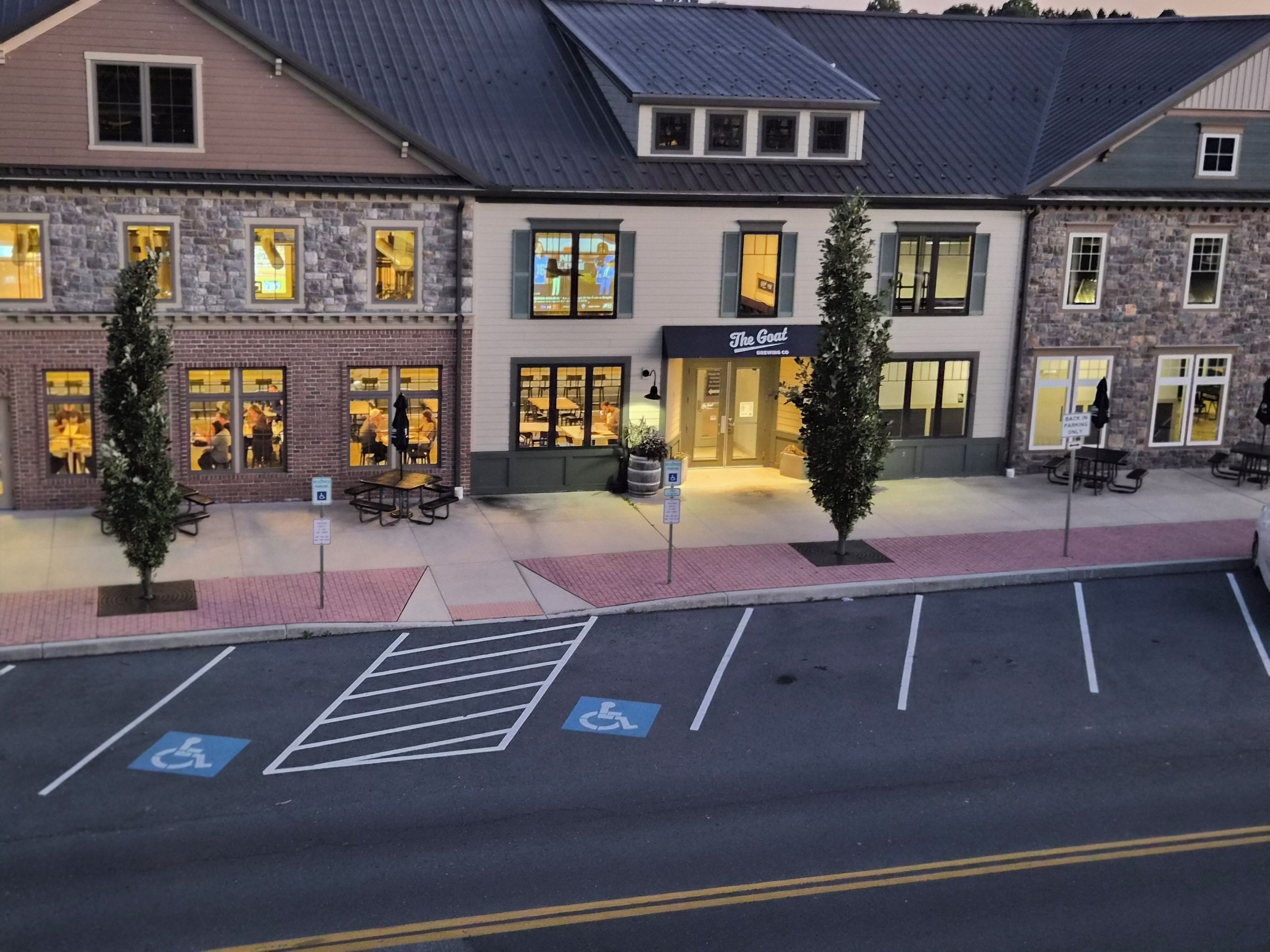 A building with a restaurant named 'The Goat' and a parking area with handicapped parking spaces.