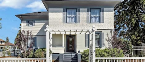 A two-story house with a front porch, a garage, and a driveway.