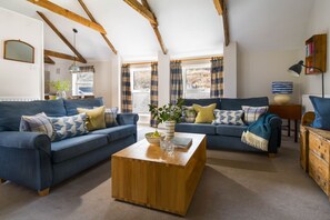 A living room with two sofas, a wooden coffee table, and a bookshelf. - Marigold Cottage - sleeps 4 guests  in 2 bedrooms (Port Gaverne)
