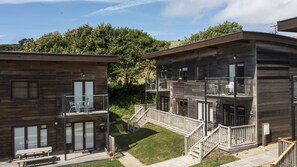 A modern two-story building with a balcony and outdoor seating area. - Mulberry Eco Beach House - sleeps 6 guests  in 3 bedrooms (Porthtowan)