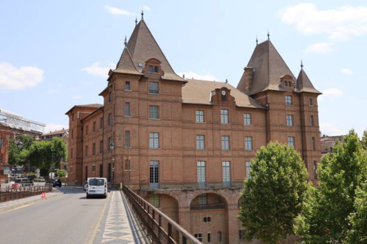 Un grand bâtiment historique doté de nombreuses tours et de fenêtres en arc.