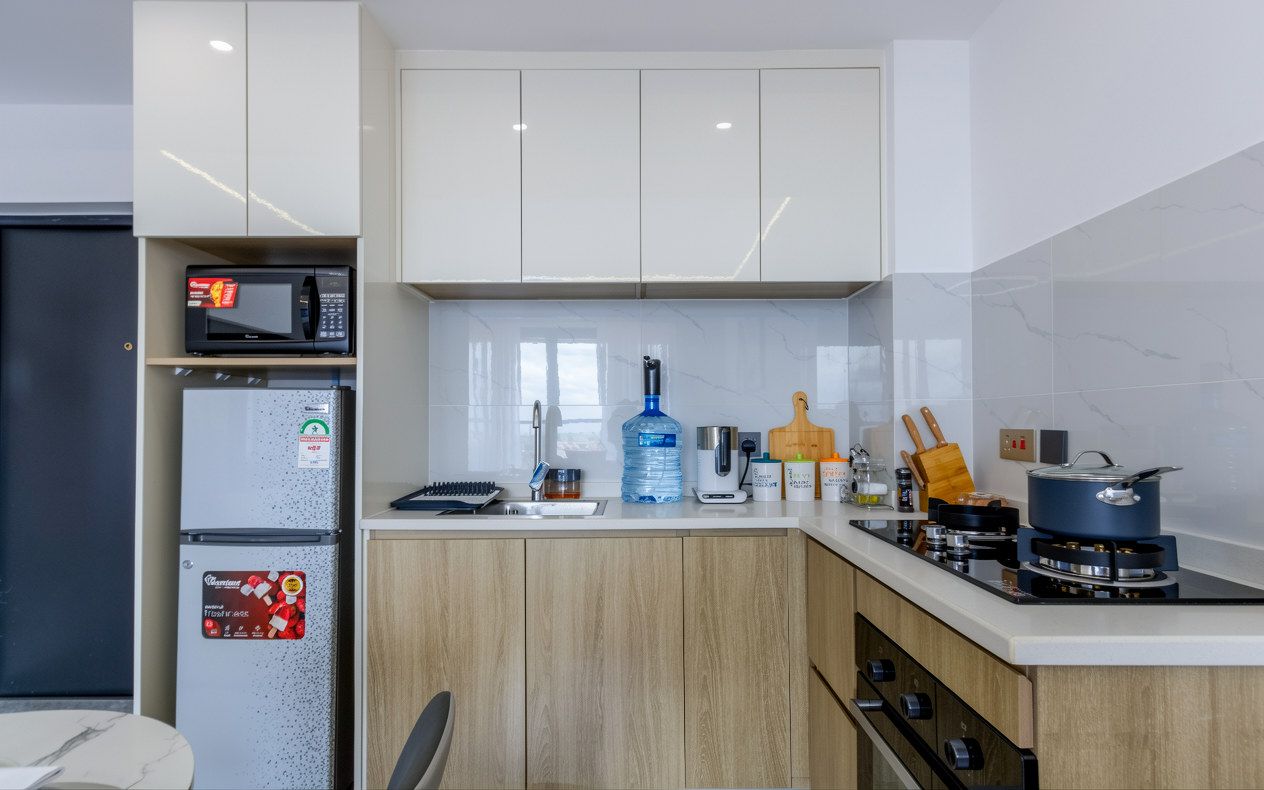Eine moderne Küche mit Einbau-Mikrowelle, Kühlschrank und Gasherd.