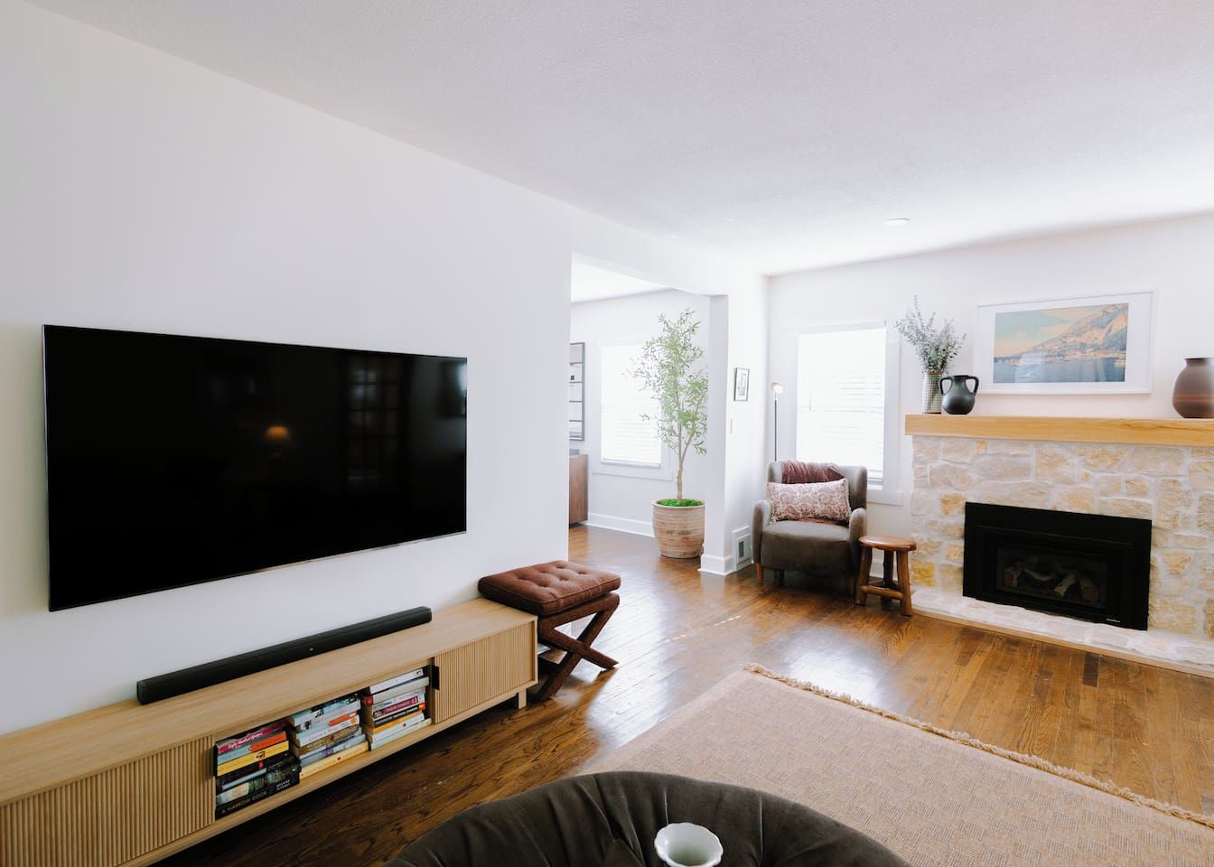 Ein modernes Wohnzimmer mit einem Flachbildfernseher, einem Kamin und einer gemütlichen Sitzecke.