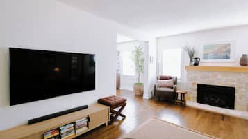 Ein modernes Wohnzimmer mit einem Flachbildfernseher, einem Kamin und einer gemütlichen Sitzecke.