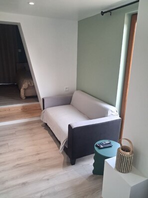 A modern room with a sofa, a small table, and a lamp.