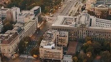 Une vue urbaine mettant en évidence un bâtiment gouvernemental imposant, de larges rues et des constructions urbaines environnantes.