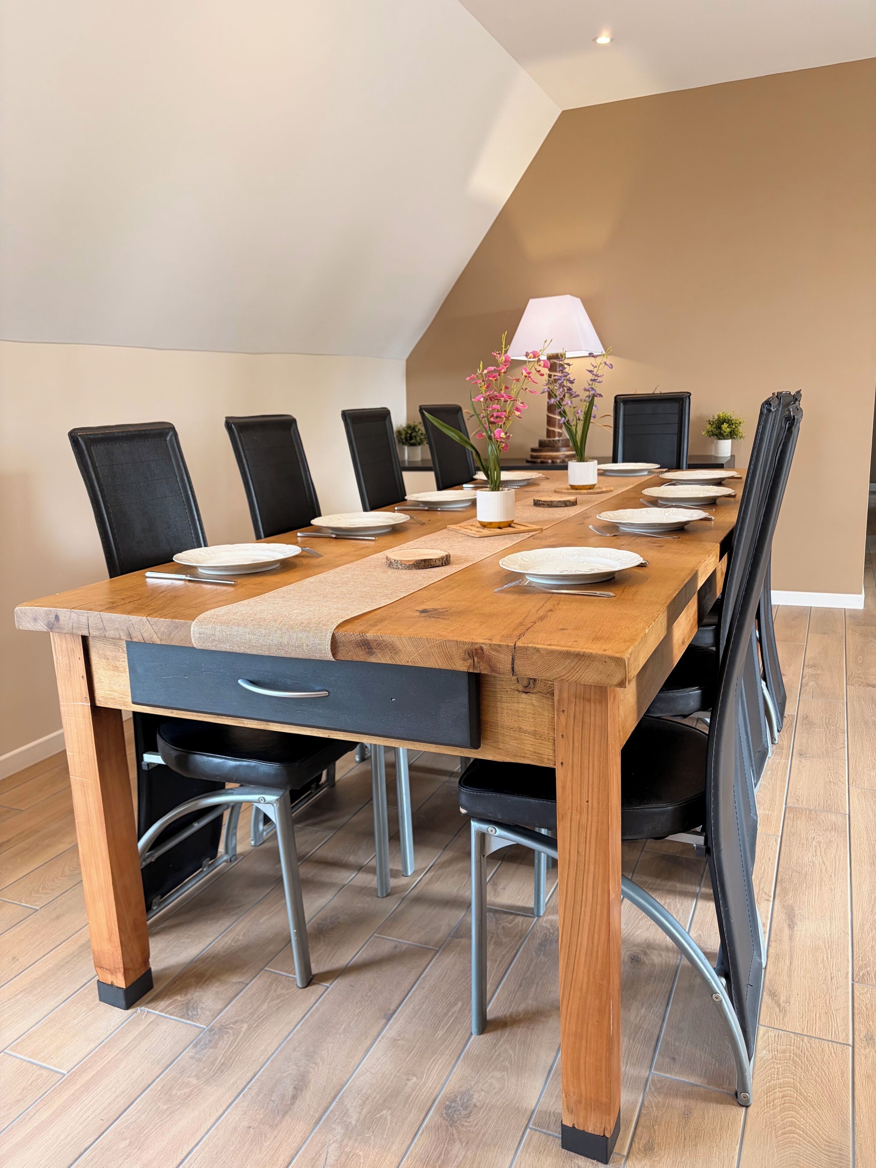 Une salle de conférence avec une longue table, des chaises et une lampe.
