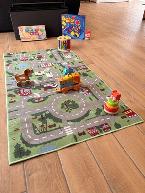 A play mat with a road layout and toy vehicles. - Grange du Pécou, a charming vacation rental, perfect for nature-loving families (Saint-Donat)