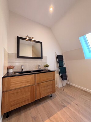 A modern bathroom with a wooden vanity, a large mirror, and a skylight. - Grange du Pécou, a charming vacation rental, perfect for nature-loving families (Saint-Donat)