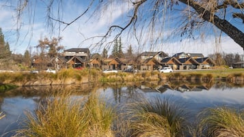 Een woongebied aan het water met moderne huizen, een rustig meer en omliggende begroeiing.