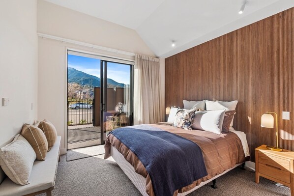 Une chambre d’hôtel avec un lit, un canapé, une table de chevet et une vue sur l’extérieur.