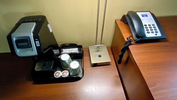 A desk with a coffee machine, a telephone, and a small box. - Premium King Suite 105–Stroll Historic Downtown Great Restaurants & Unique Shops (Grants Pass)