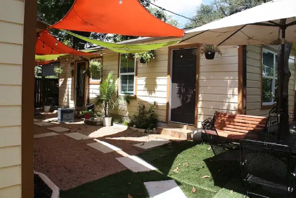 A covered patio area with outdoor furniture and potted plants.