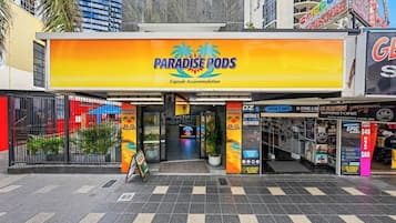 Un hotel llamado Paradise Pods con un cartel de alojamiento tipo cápsula.