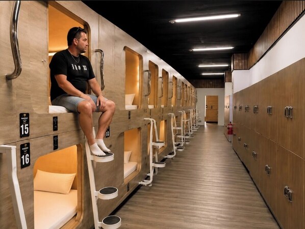 A row of individual changing rooms with benches and lockers.