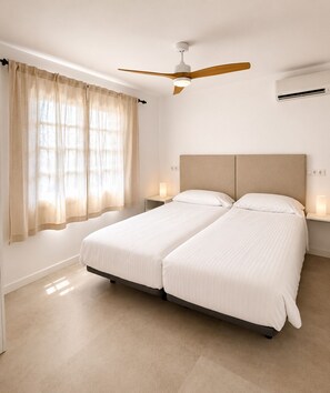 A double bed with a wooden headboard in a hotel room. - Villa Lava - 3-Bedroom Villa in Downtown Puerto del Carmen (Tías)